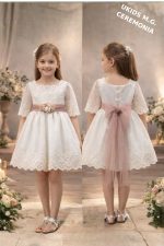 Vestido niña ceremonia elegante color crudo con fajín rosa empolvado.Arras, boda y eventos